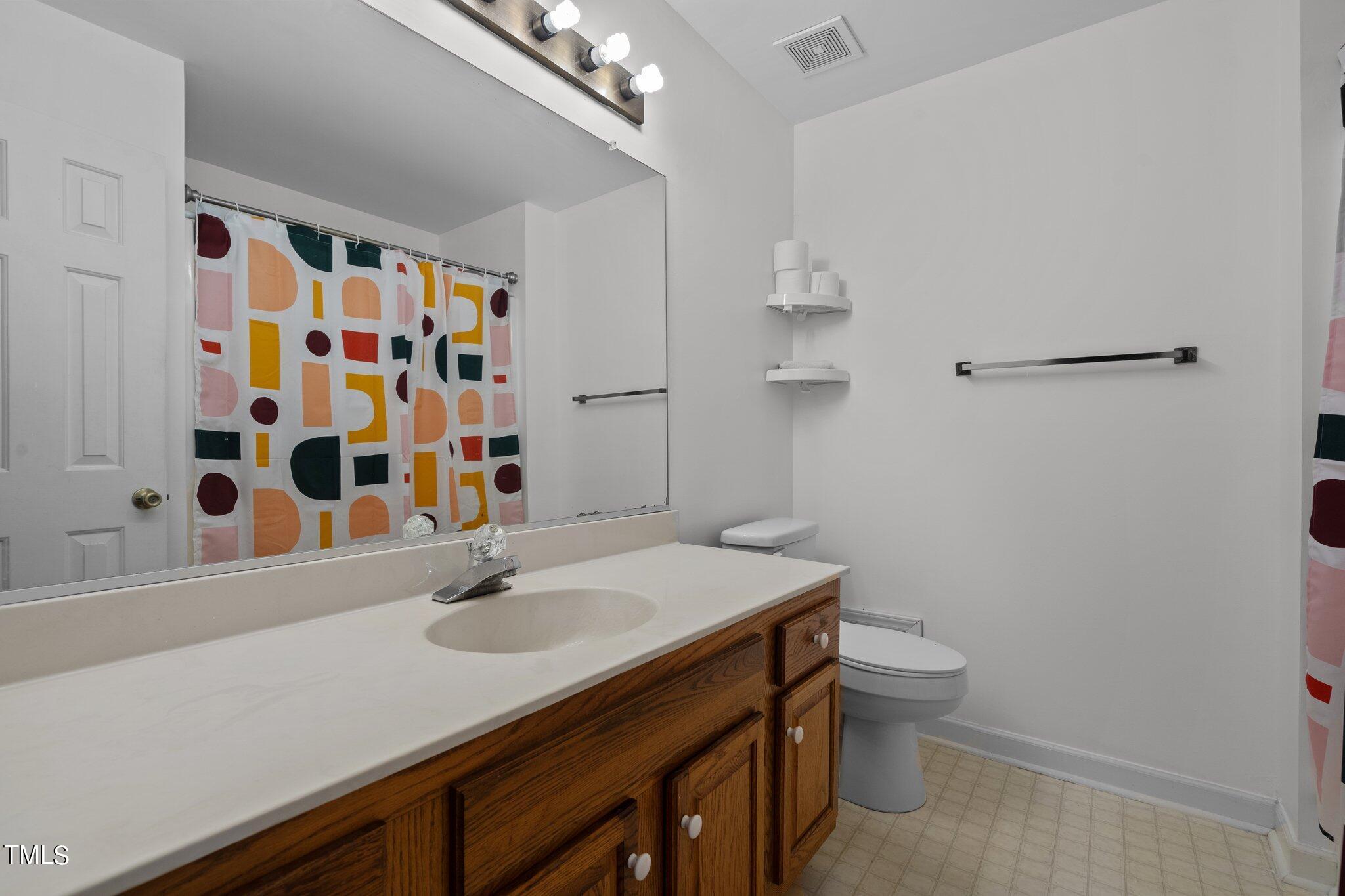 3520 Rawdon Drive Durham, NC 27713 - Photo 18 of 30 a bathroom with a sink a toilet a shower and a mirror