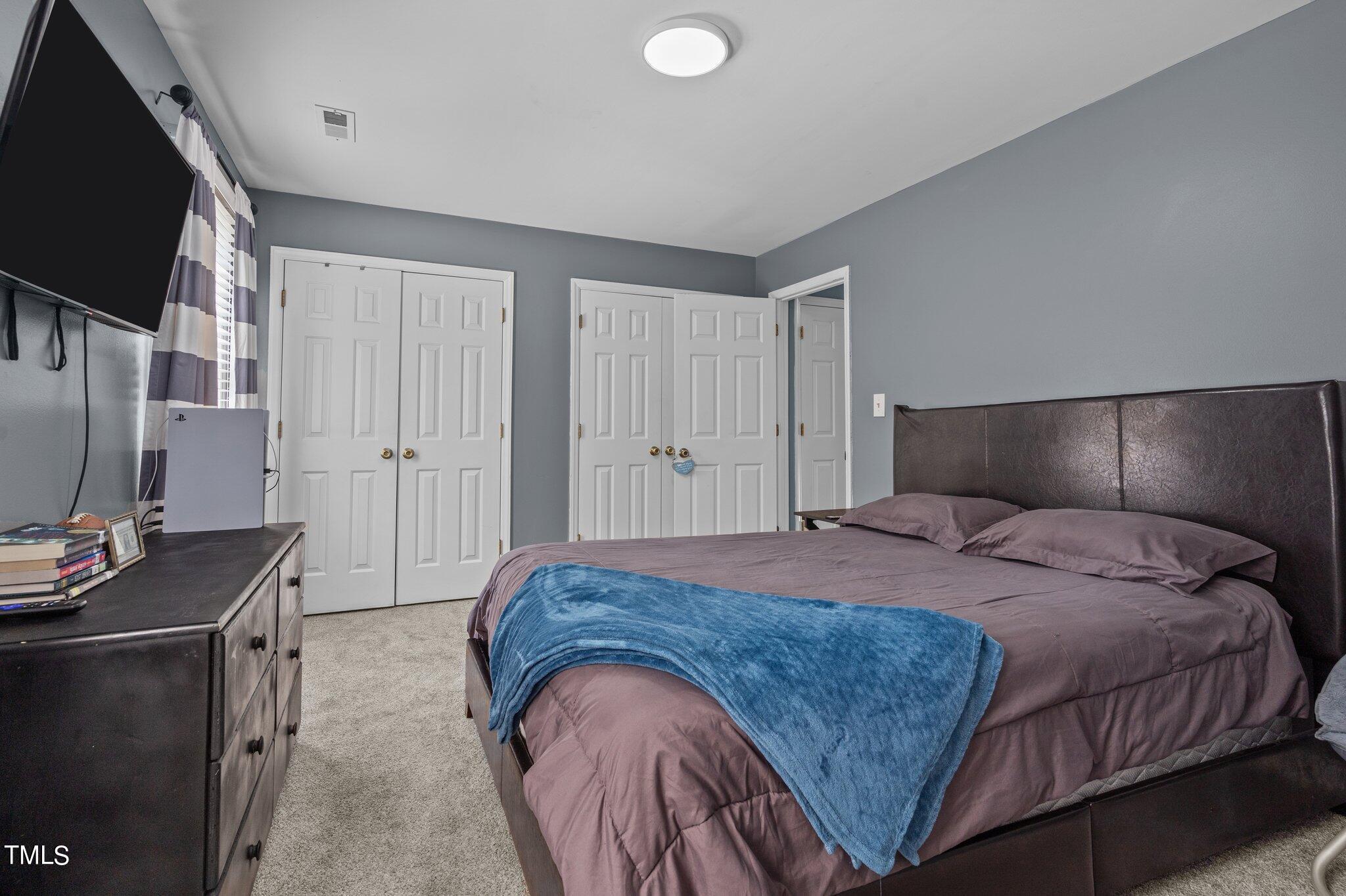 3520 Rawdon Drive Durham, NC 27713 - Photo 21 of 30 a bedroom with a bed and a flat screen tv