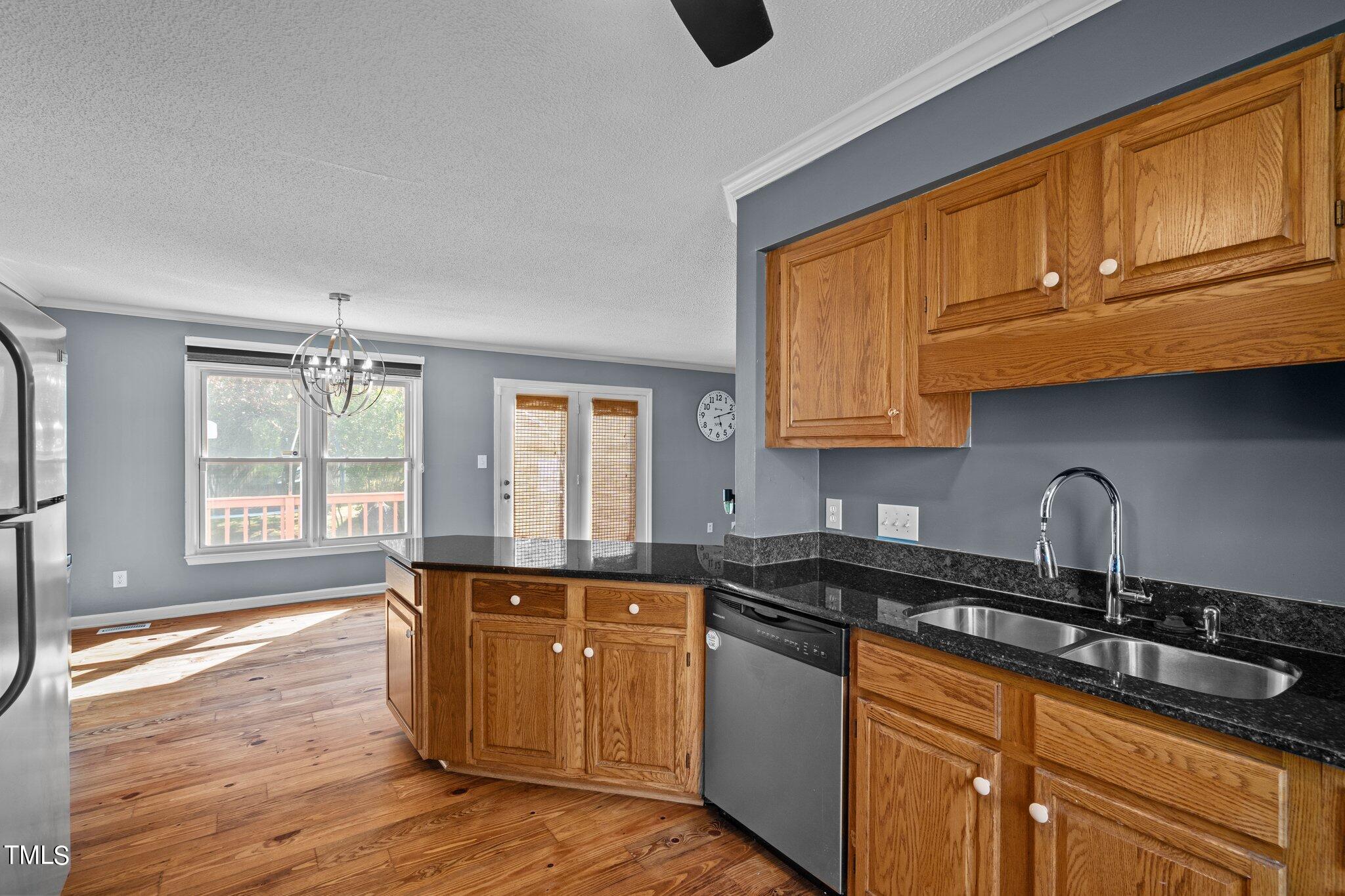 3520 Rawdon Drive Durham, NC 27713 - Photo 10 of 30 a kitchen with granite countertop wooden cabinets a sink and wooden floors