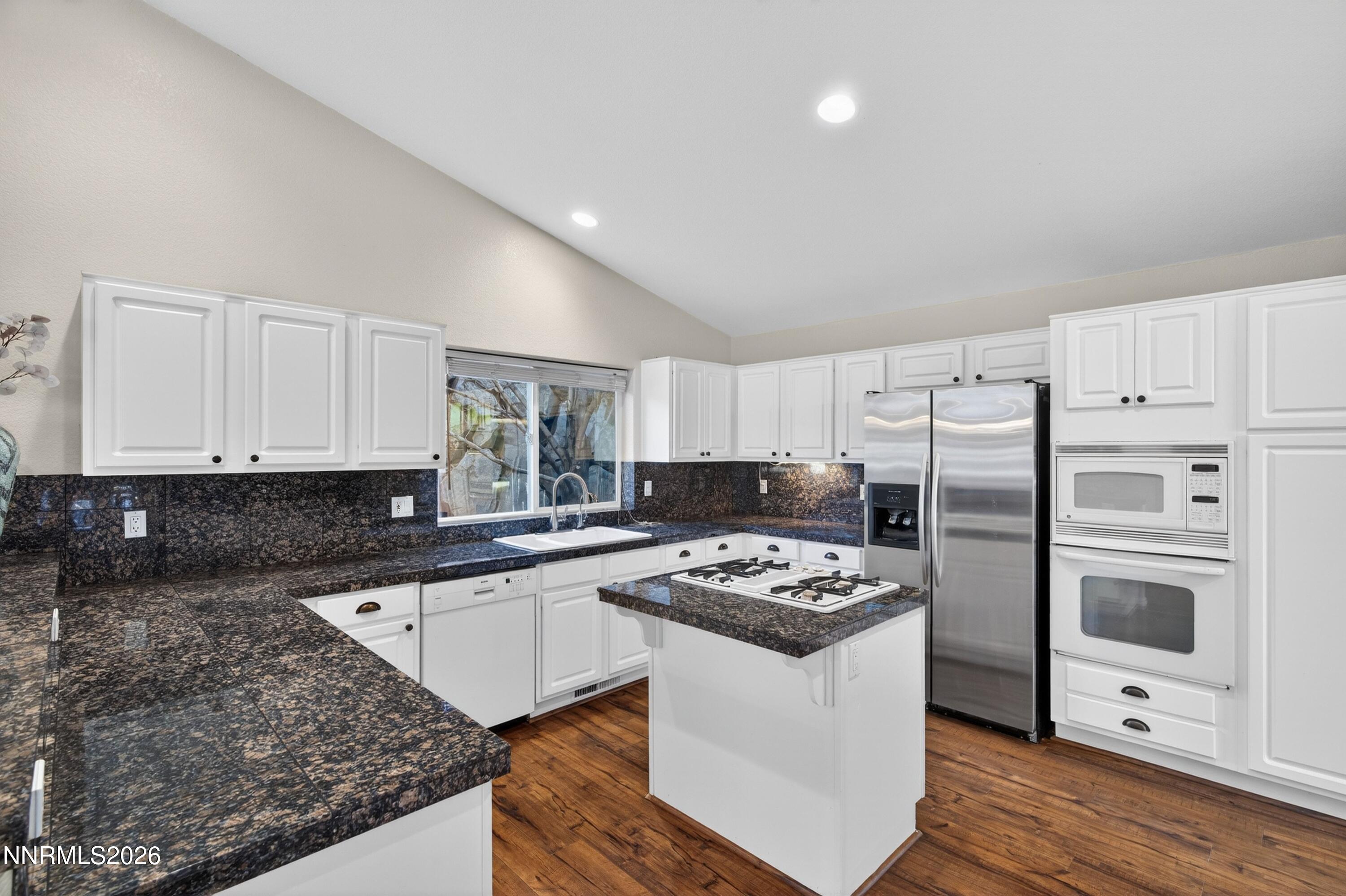 6279 Golden Meadow Road Reno, NV 89519 - Photo 15 of 57 a kitchen with stainless steel appliances kitchen island granite countertop a sink stove and refrigerator