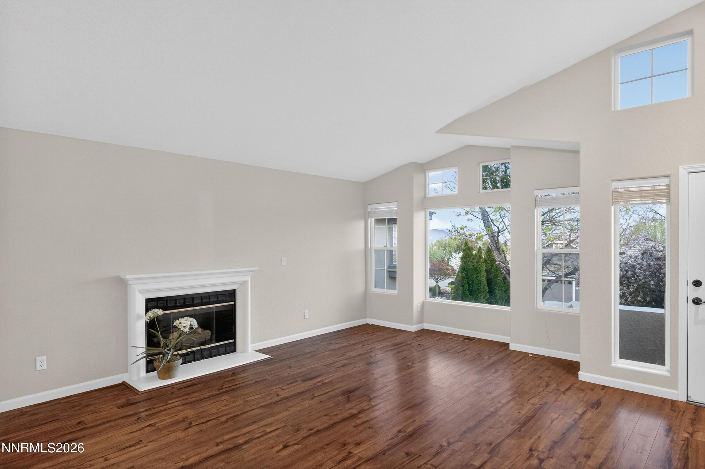 6279 Golden Meadow Road Reno, NV 89519 - Photo 3 of 57 an empty room with wooden floor a fireplace and windows