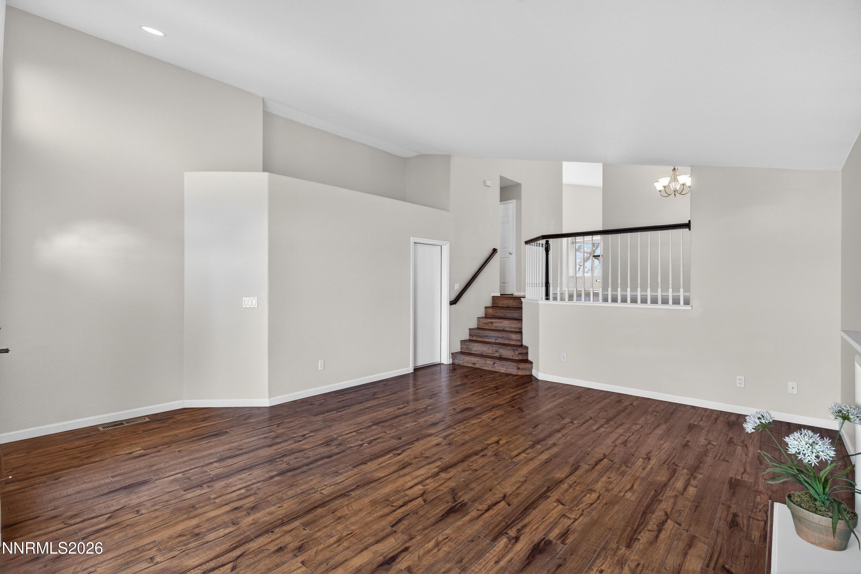 6279 Golden Meadow Road Reno, NV 89519 - Photo 7 of 57 a view of an empty room with wooden floor and stairs