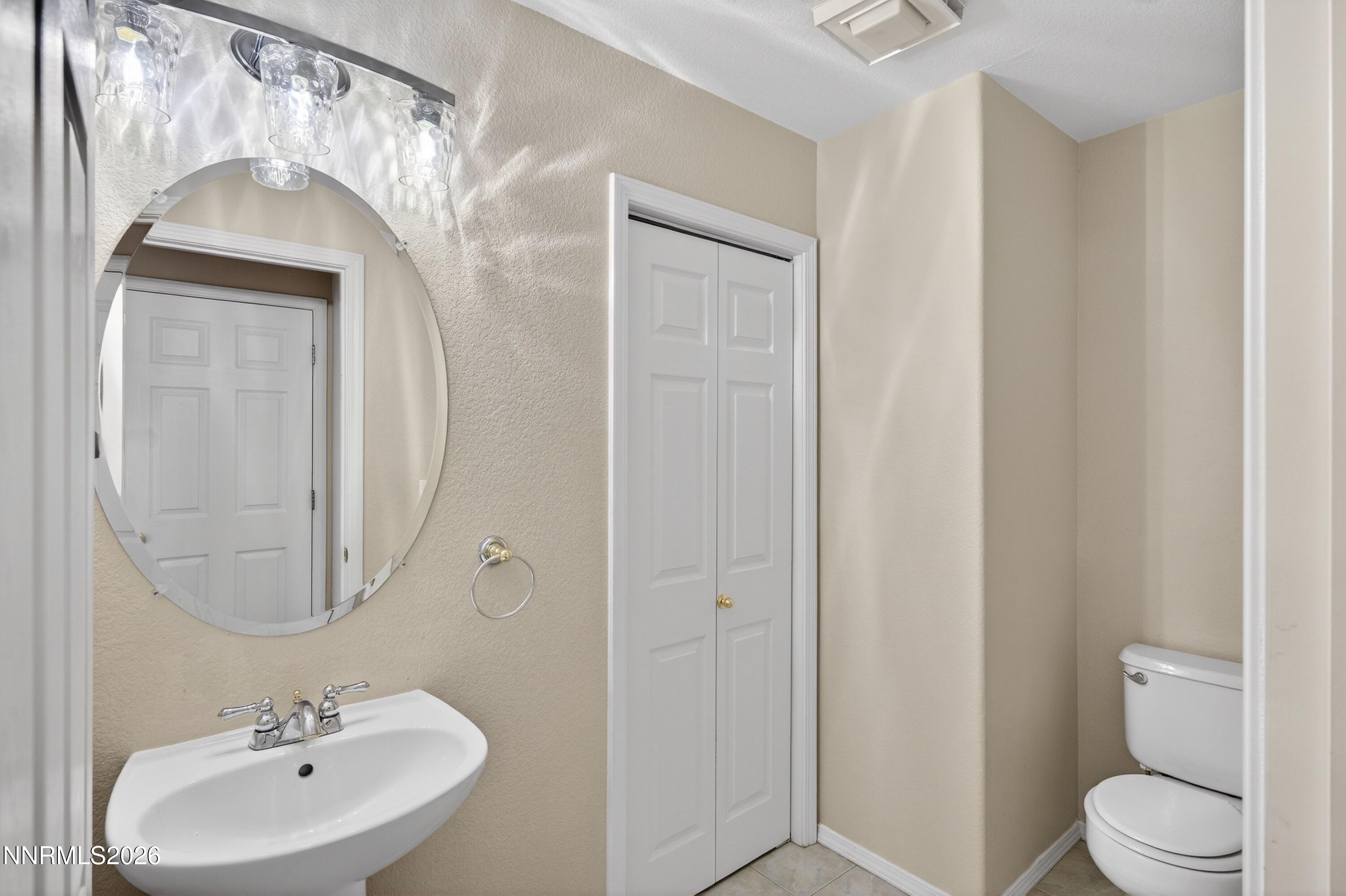 6279 Golden Meadow Road Reno, NV 89519 - Photo 9 of 57 a bathroom with a toilet a sink and mirror