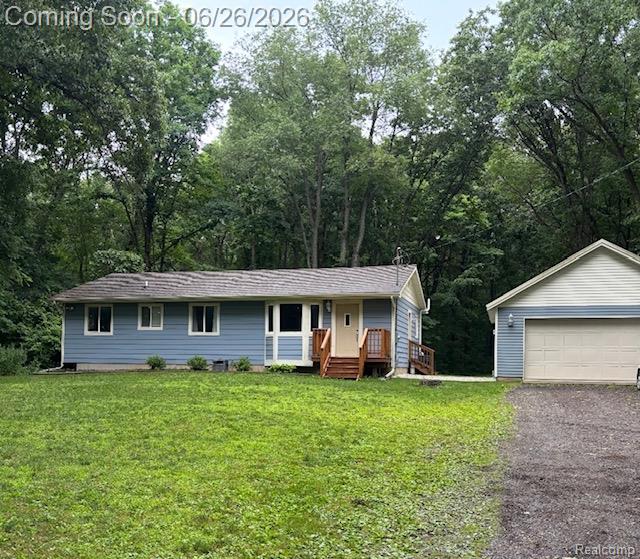 11211 Boyce Road Chelsea, MI 48118 - Photo 1 of 22 Light blue siding residence with a detached garage, wood deck, and surrounding mature trees