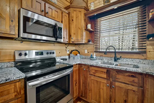 a kitchen with granite countertop a stove and a sink