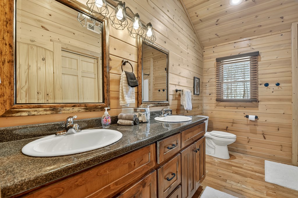 78 Brass Hill Road Blue Ridge, GA 30513 - Photo 31 of 44 a bathroom with a granite countertop sink a toilet a mirror and a window