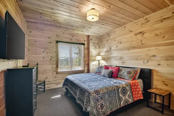 a bedroom with a bed and a flat screen tv