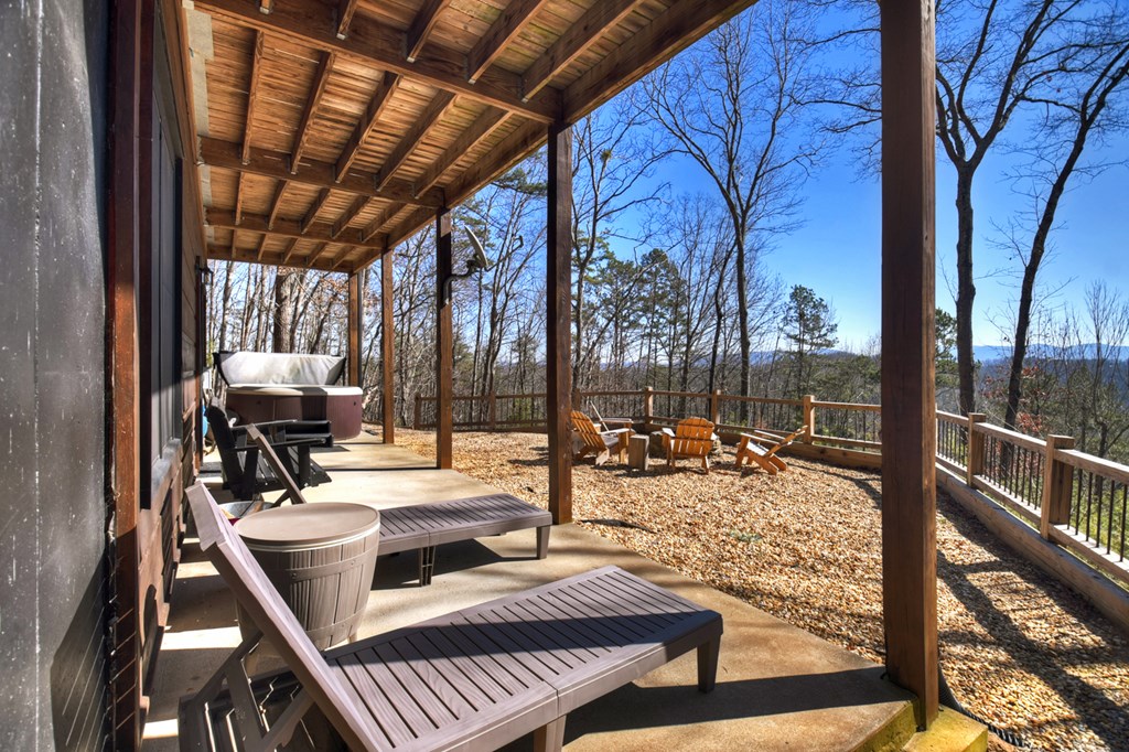 78 Brass Hill Road Blue Ridge, GA 30513 - Photo 43 of 44 a view of a patio with couches table and chairs and wooden floor next to a yard