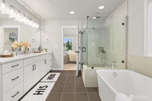 a spacious bathroom with a double vanity sink a large mirror a bathtub and shower