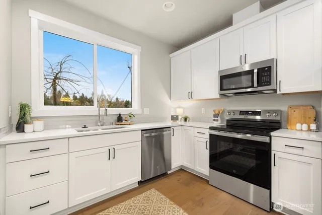 a kitchen with stainless steel appliances granite countertop a stove a sink and a microwave