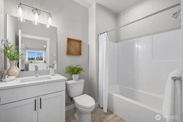 a bathroom with a sink toilet a mirror and shower