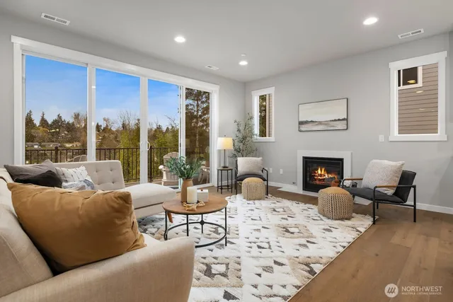 a living room with furniture a fireplace and a floor to ceiling window