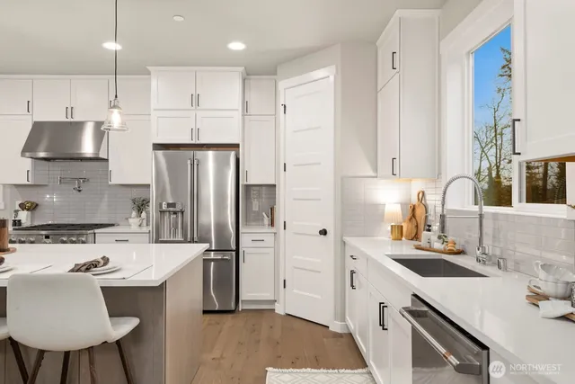a kitchen with kitchen island a sink stainless steel appliances and cabinets