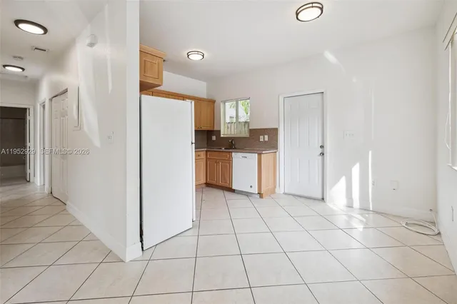 a kitchen with white cabinets and refrigerator