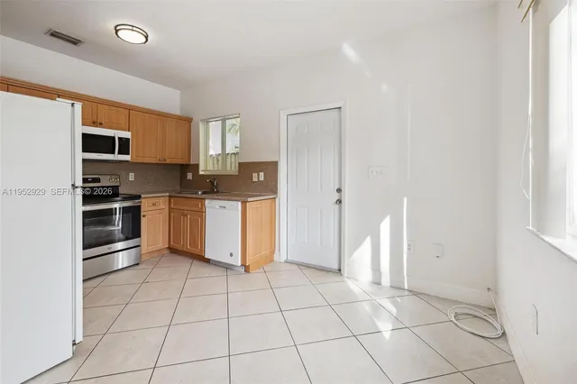 a kitchen with a stove a sink and a refrigerator