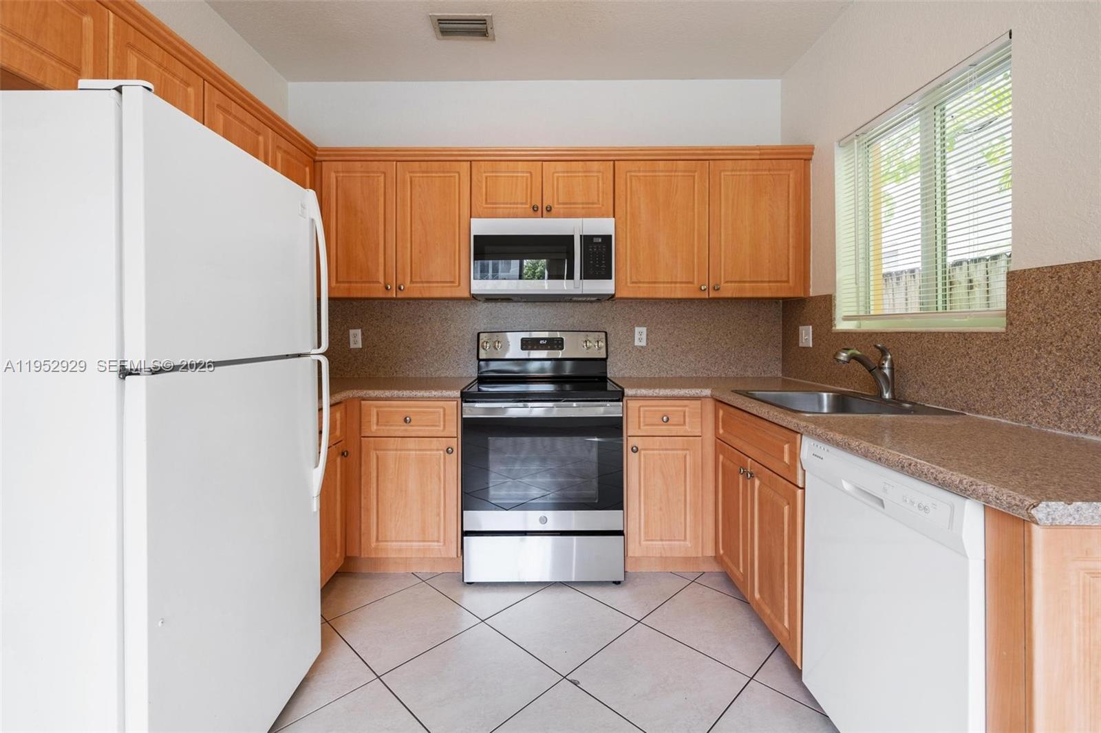 3134 Hibiscus Street, Unit 3134 Miami, FL 33133 - Photo 16 of 21 a kitchen with granite countertop a refrigerator and a sink