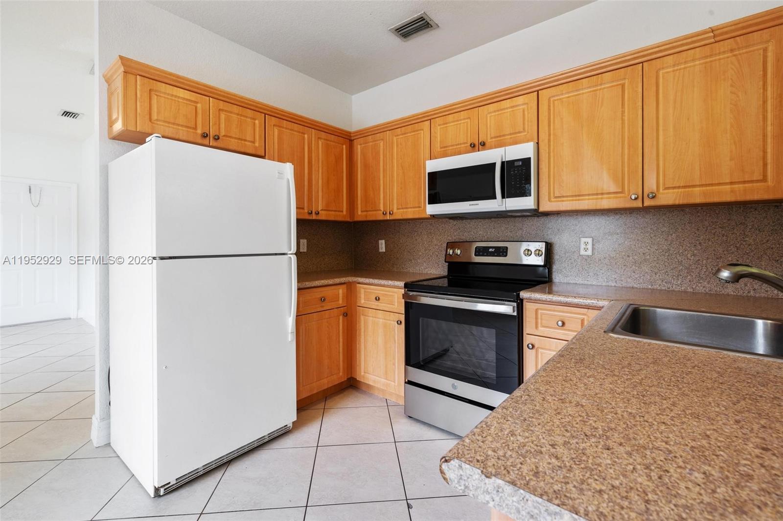 3134 Hibiscus Street, Unit 3134 Miami, FL 33133 - Photo 17 of 21 a kitchen with a refrigerator sink and cabinets