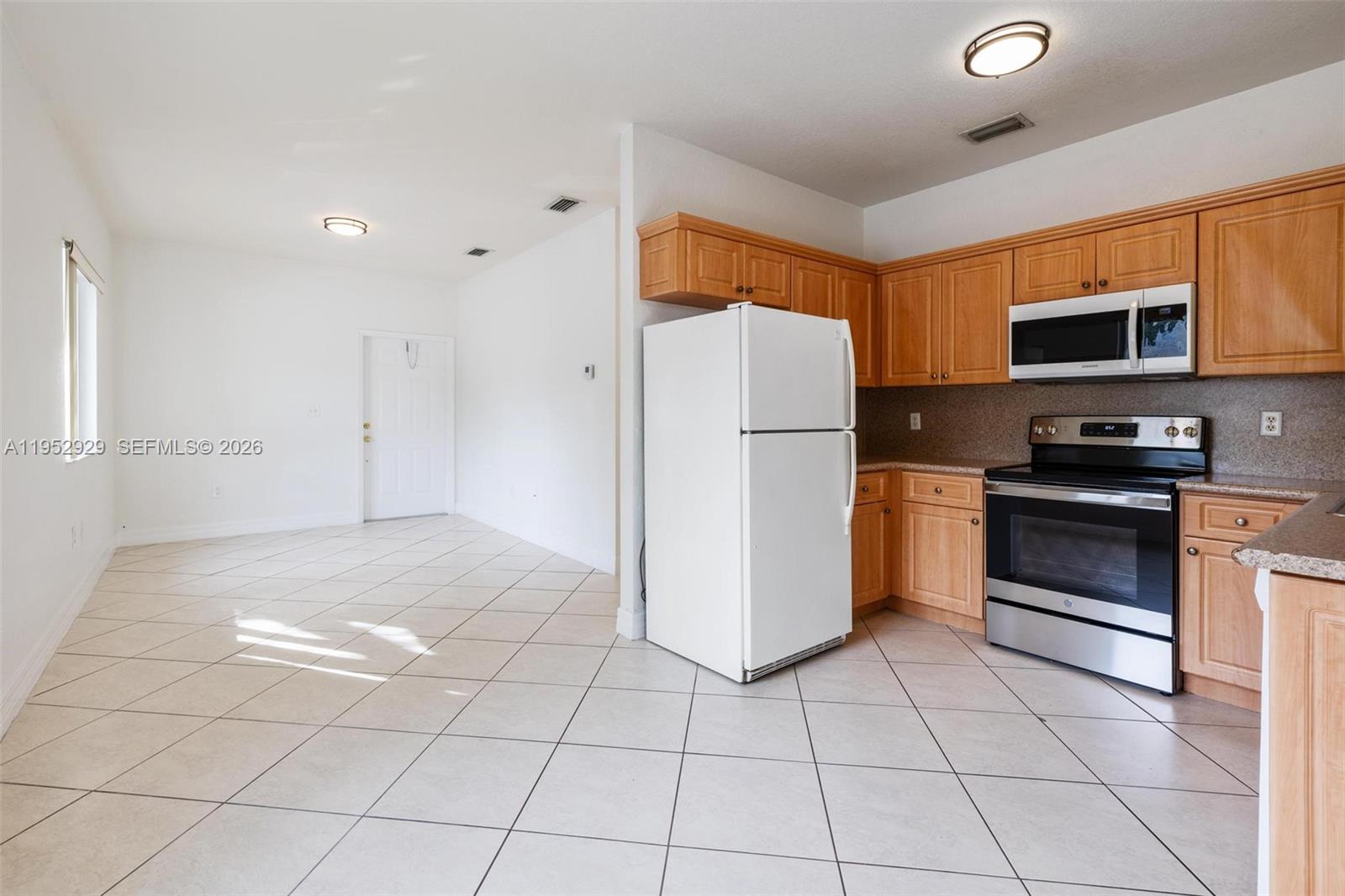 3134 Hibiscus Street, Unit 3134 Miami, FL 33133 - Photo 18 of 21 a kitchen with a refrigerator a stove top oven and cabinets