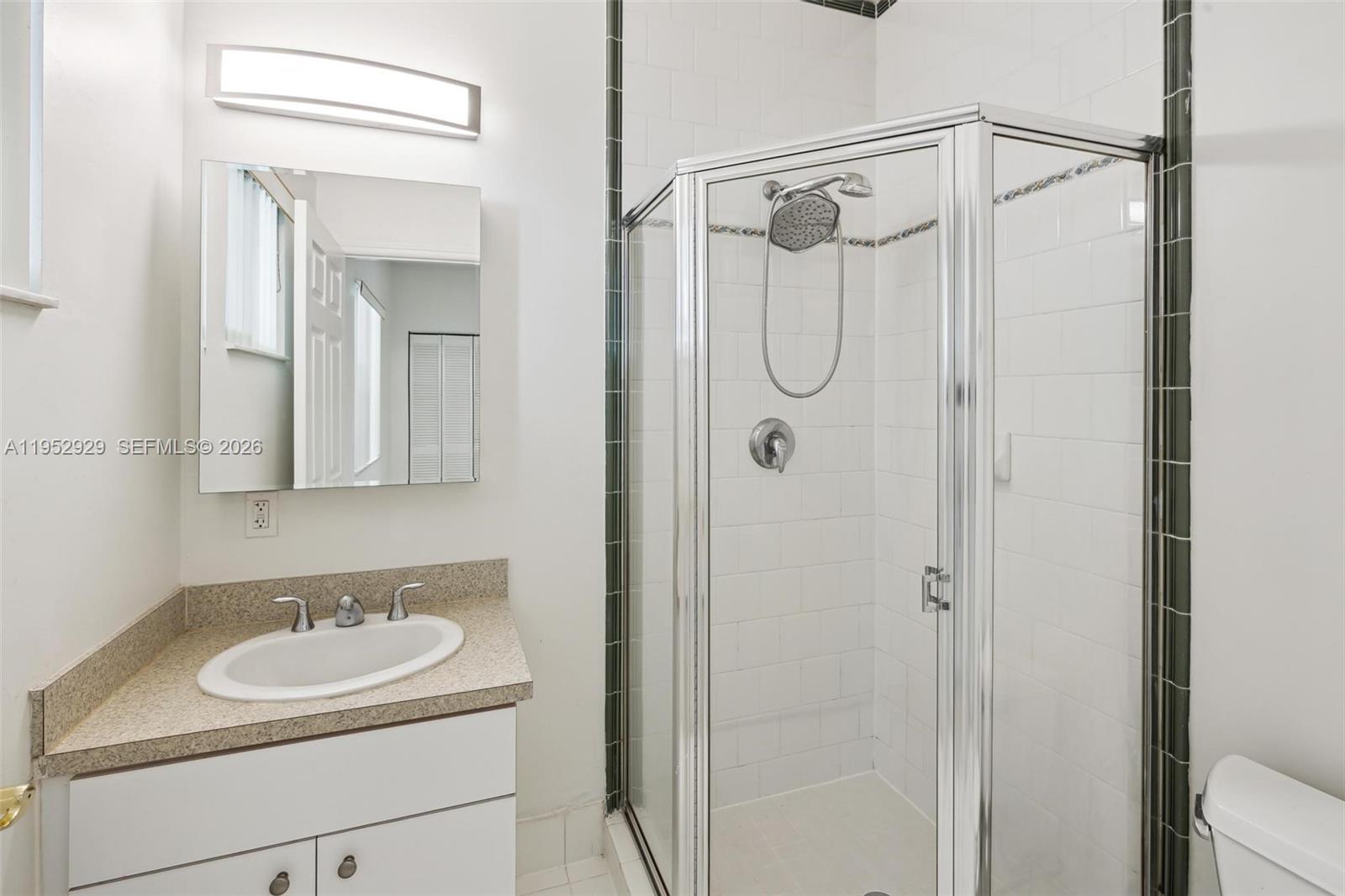 3134 Hibiscus Street, Unit 3134 Miami, FL 33133 - Photo 6 of 21 a bathroom with a sink a mirror a vanity and a shower