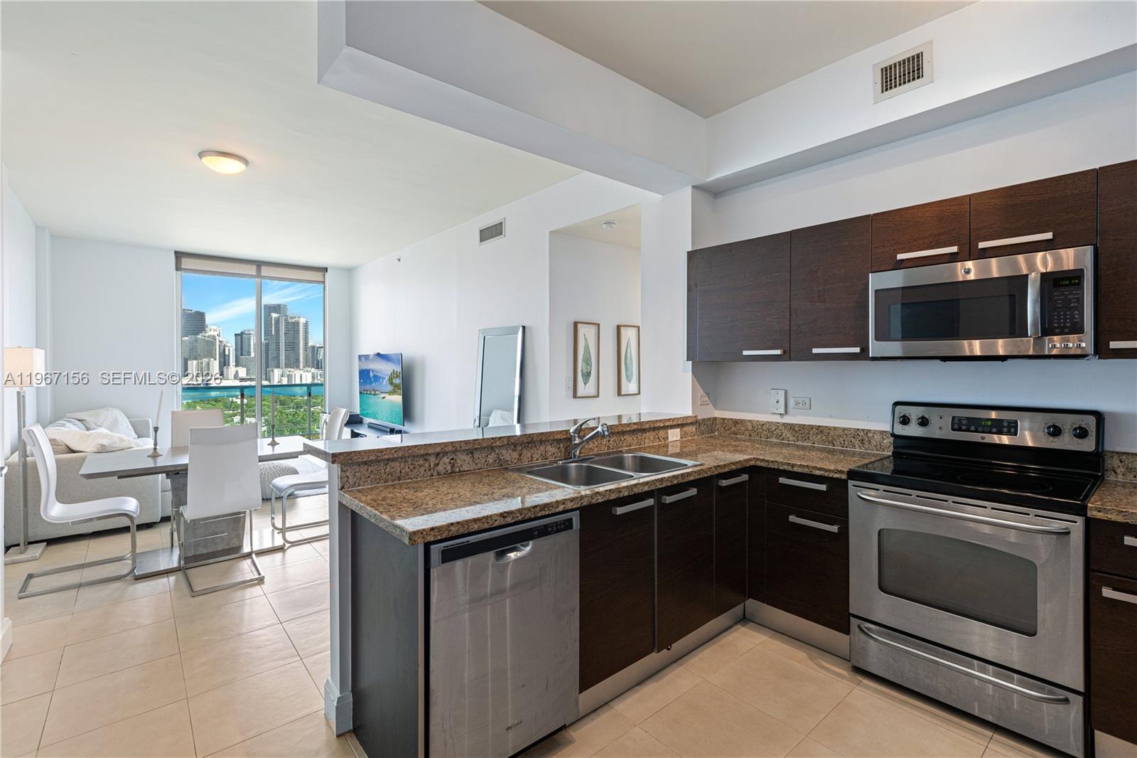 2525 Southwest 3rd Avenue, Unit 1708 Miami, FL 33129 - Photo 18 of 26 a kitchen with a sink stove and microwave