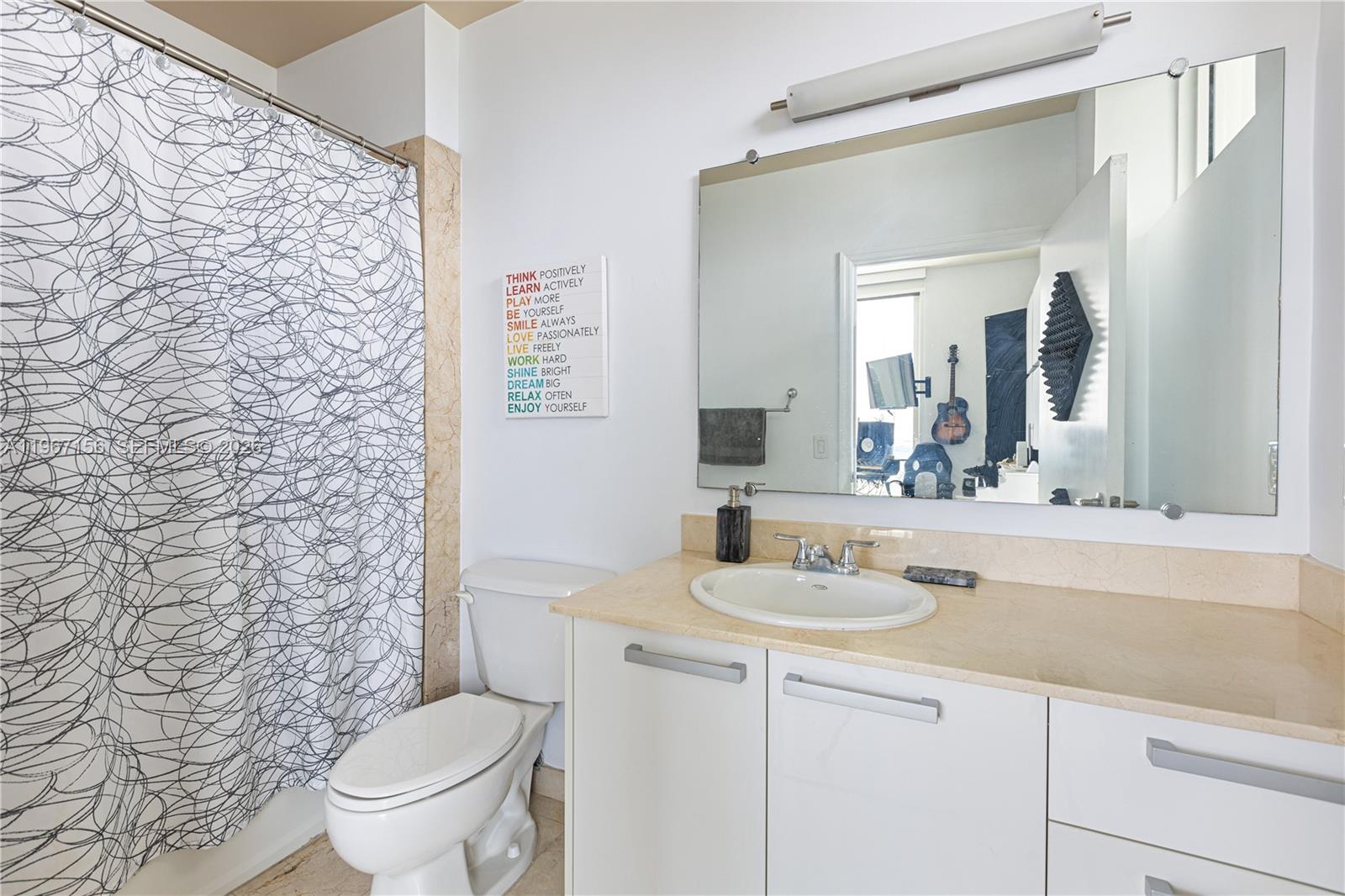 2525 Southwest 3rd Avenue, Unit 1708 Miami, FL 33129 - Photo 7 of 26 a bathroom with a granite countertop sink a toilet and a mirror