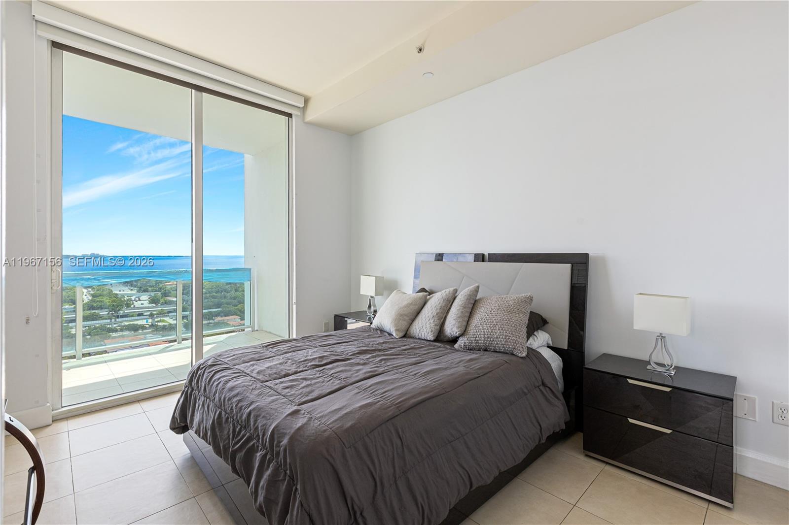 2525 Southwest 3rd Avenue, Unit 1708 Miami, FL 33129 - Photo 9 of 26 a bed sitting in a bedroom next to a window