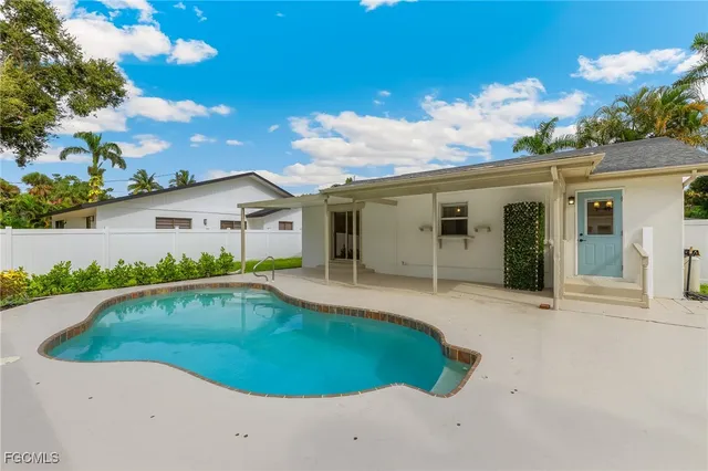 a view of a white house with a swimming pool