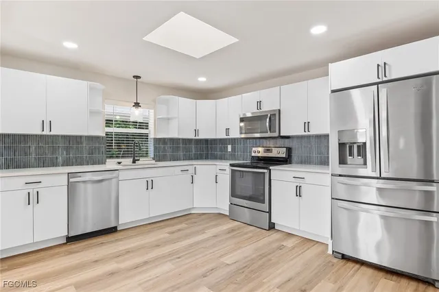 a kitchen with granite countertop white cabinets and white appliances