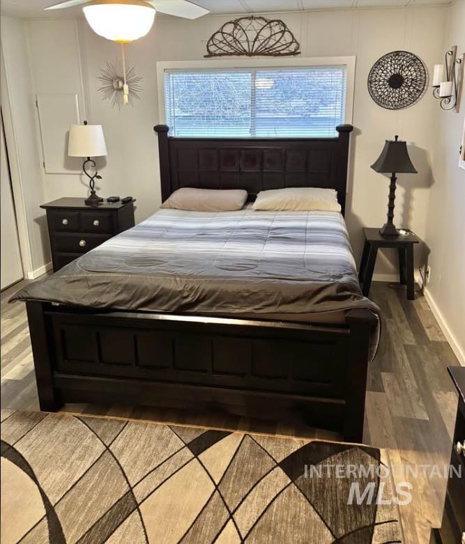 3181 West Alpine Street, Unit 22 Boise, ID 83705 - Photo 12 of 24 Bedroom featuring wood finished floors, ceiling fan, and multiple windows
