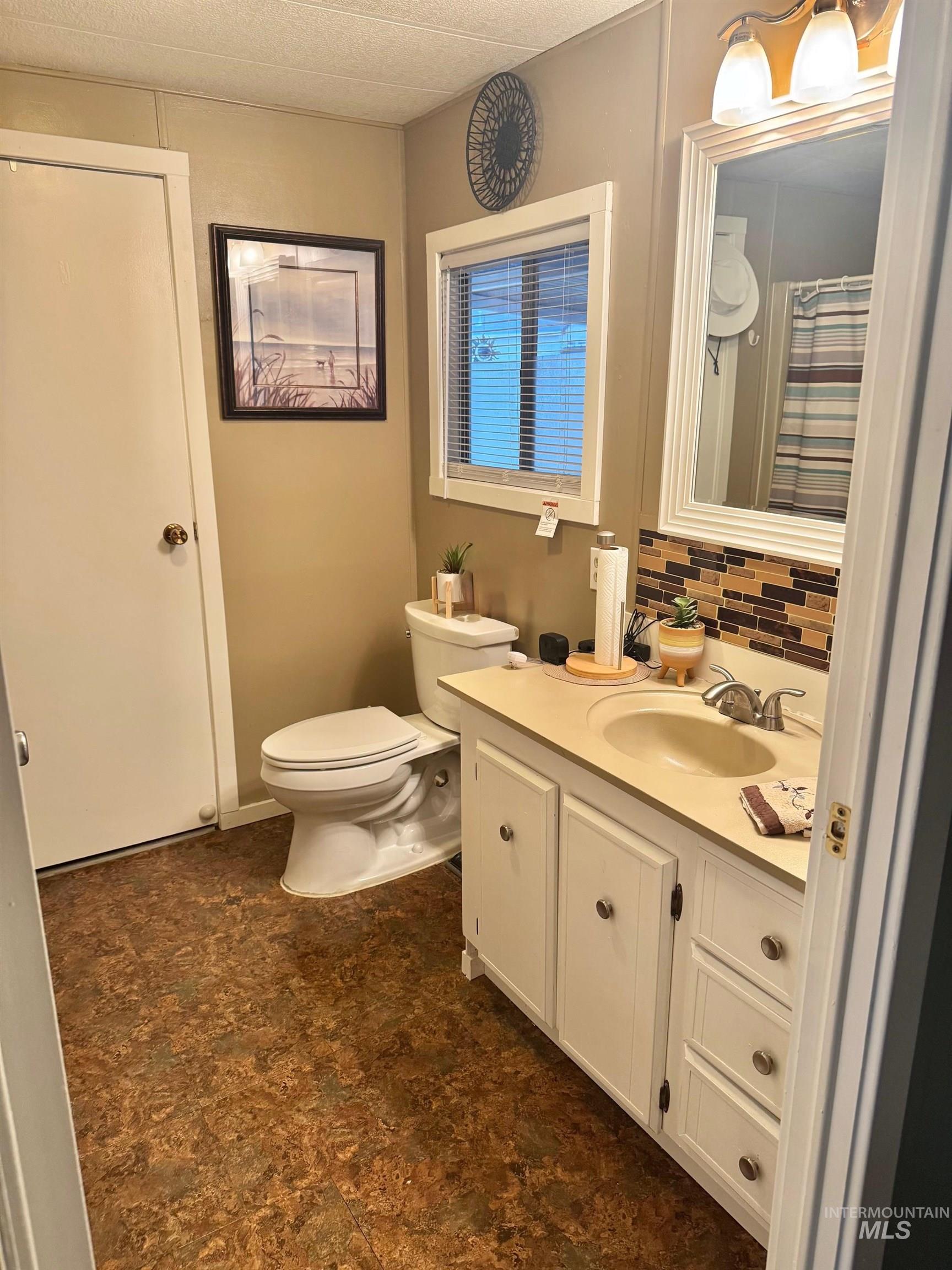3181 West Alpine Street, Unit 22 Boise, ID 83705 - Photo 19 of 24 Bathroom with vanity, a shower with curtain, and tasteful backsplash