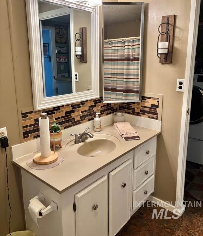 3181 West Alpine Street, Unit 22 Boise, ID 83705 - Photo 20 of 24 Full bathroom featuring vanity, washer / dryer, curtained shower, and decorative backsplash