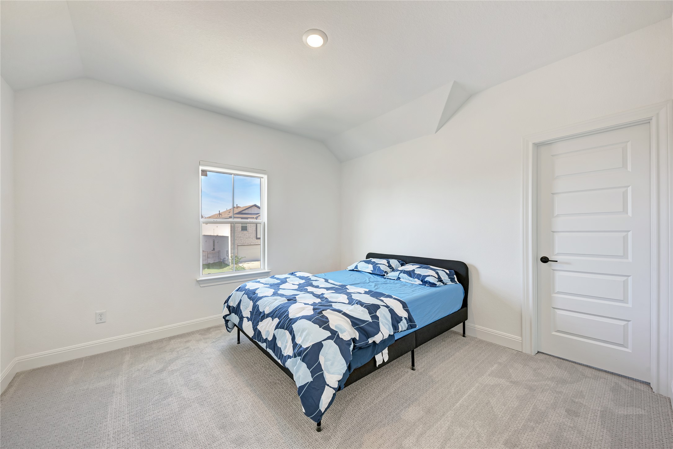 316 Regatta Trail Leander, TX 78641 - Photo 28 of 39 Carpeted bedroom featuring a single window, white paneled door, vaulted ceiling, and recessed lighting