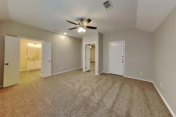 an empty room with closet and a ceiling fan