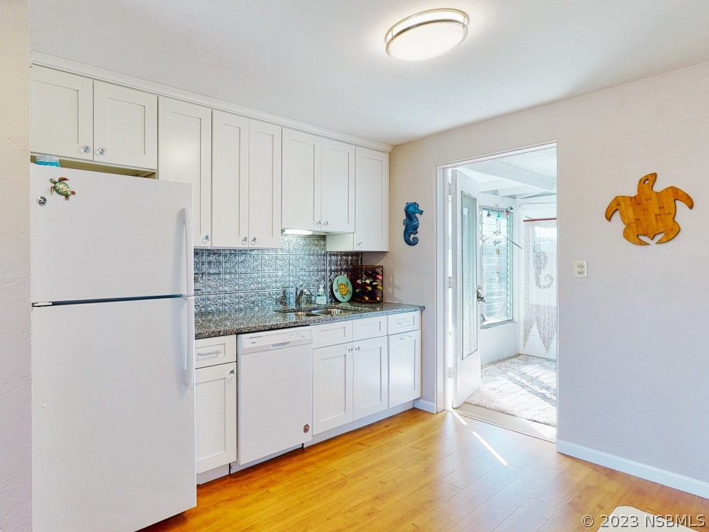 37 Ocean Shore Drive Ormond Beach, FL 32176 - Photo 12 of 50 a kitchen with a refrigerator a stove top oven and cabinets
