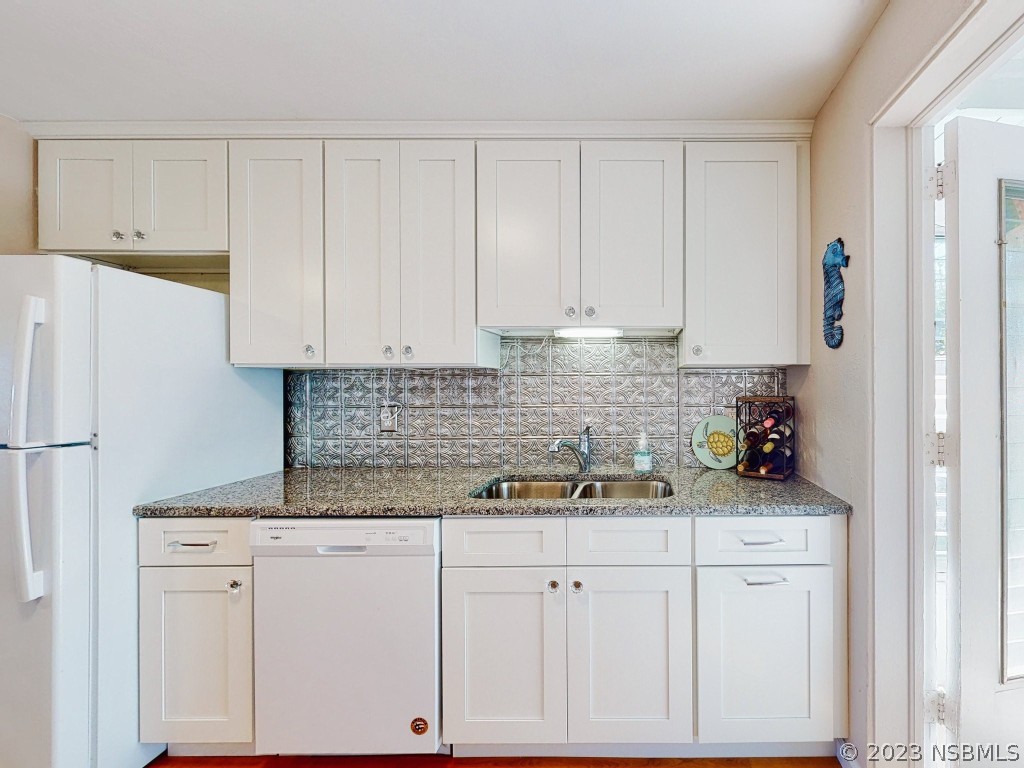 37 Ocean Shore Drive Ormond Beach, FL 32176 - Photo 19 of 50 a kitchen with white cabinets and white appliances