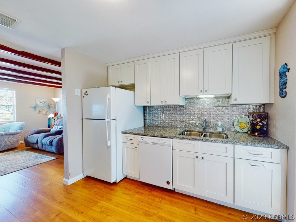 37 Ocean Shore Drive Ormond Beach, FL 32176 - Photo 10 of 50 a kitchen with sink cabinets and wooden floor