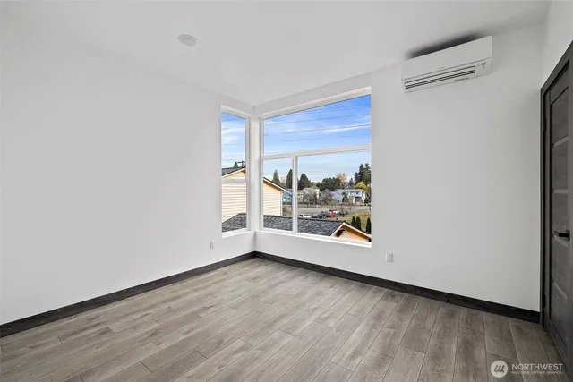 a view of a room with wooden floor and a window