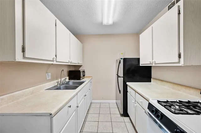 a kitchen with white cabinets and appliances