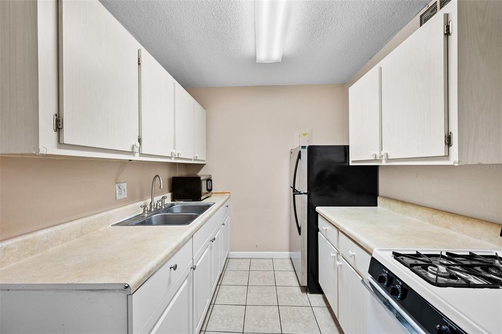 1700 Southwest 16th Court, Unit D24 Gainesville, FL 32608 - Photo 11 of 25 a kitchen with a sink stove and refrigerator
