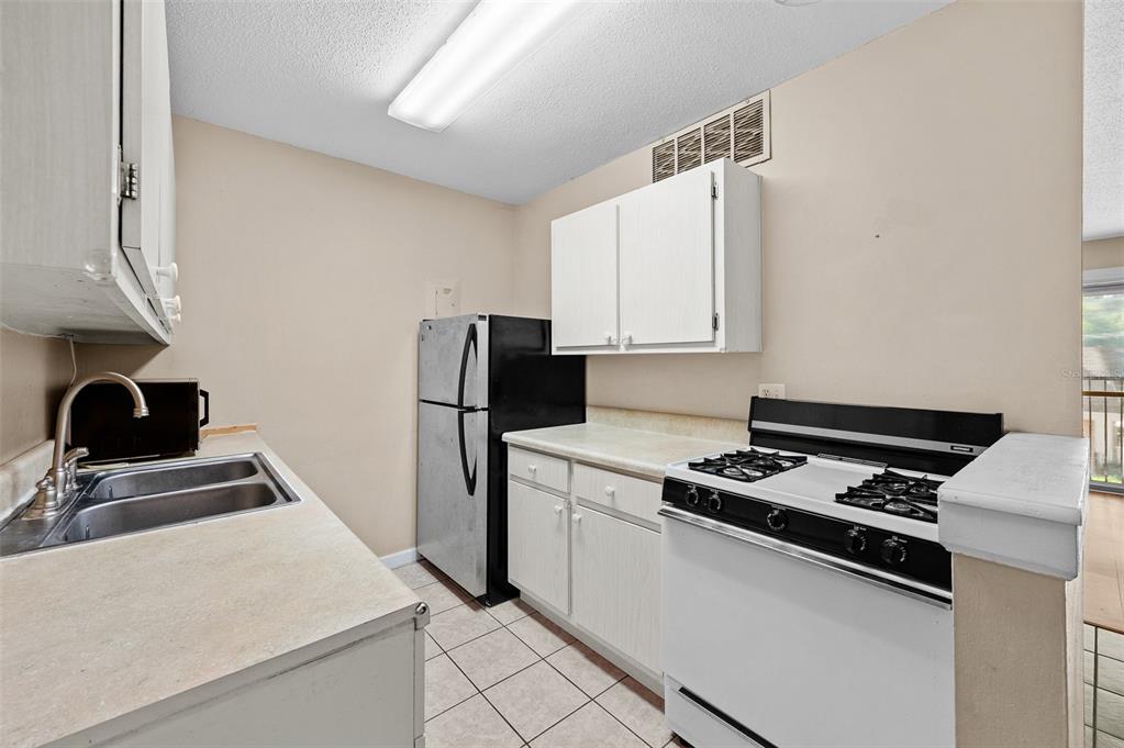 1700 Southwest 16th Court, Unit D24 Gainesville, FL 32608 - Photo 12 of 25 a kitchen with white cabinets and appliances