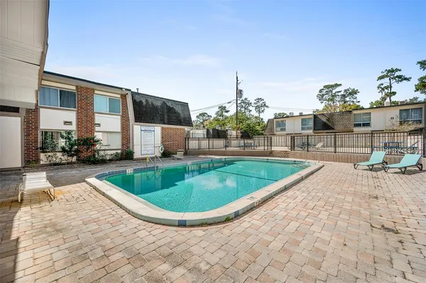 a view of a house with a swimming pool and sitting area