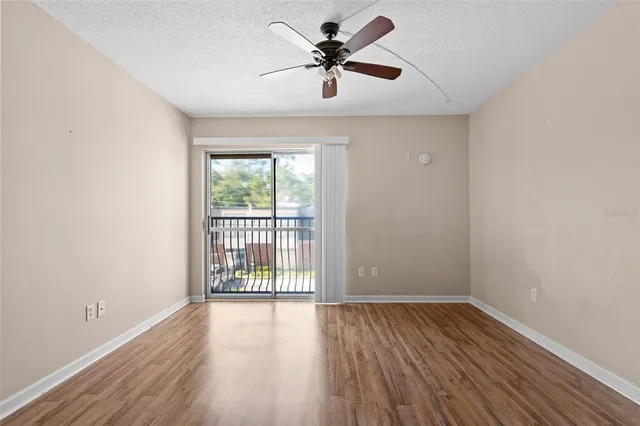 a view of a livingroom with wooden floor and a ceiling fan