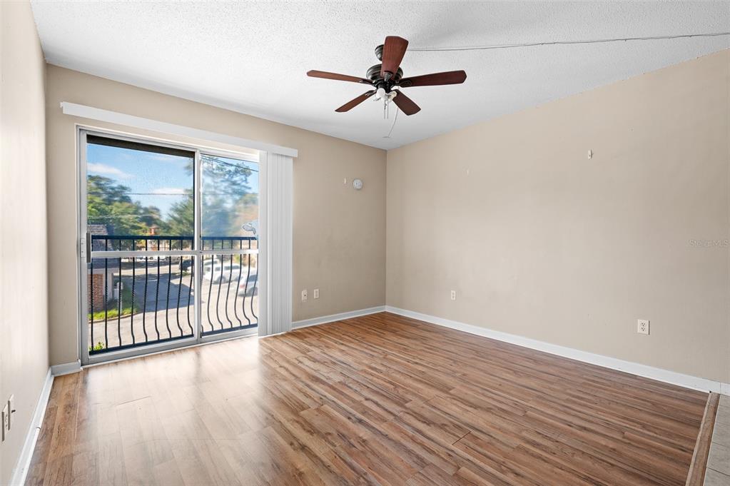 1700 Southwest 16th Court, Unit D24 Gainesville, FL 32608 - Photo 6 of 25 a view of a livingroom with wooden floor and a ceiling fan