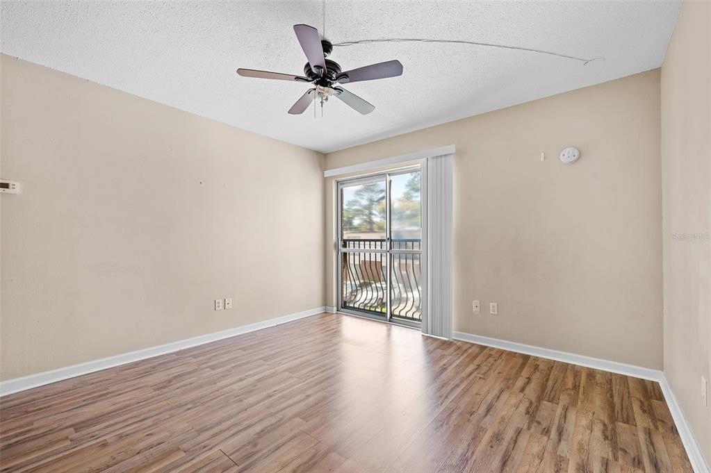 1700 Southwest 16th Court, Unit D24 Gainesville, FL 32608 - Photo 7 of 25 a view of empty room with wooden floor and fan