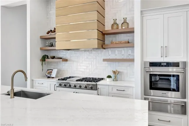 a kitchen with stainless steel appliances a stove a sink and cabinets