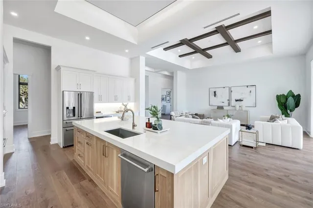 a kitchen with a stove a refrigerator and a dining table with wooden floor