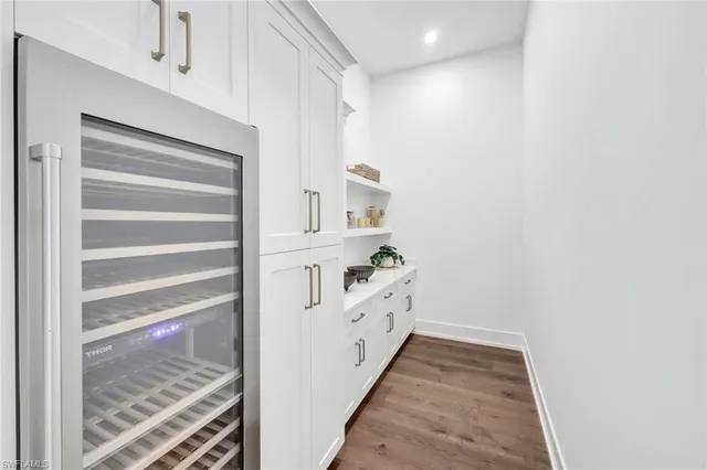 a kitchen with a stove a refrigerator and a dining table with wooden floor