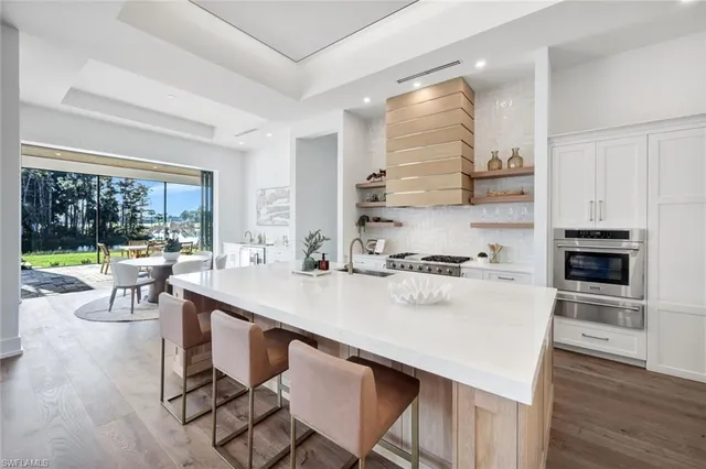a dining room with furniture a chandelier and wooden floor