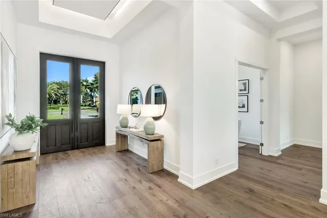 a view of a hallway with wooden floor and a living room
