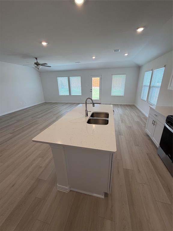 2203 Rannoch Street Sherman, TX 75092 - Photo 5 of 13 a kitchen with a wooden floor and white cabinets